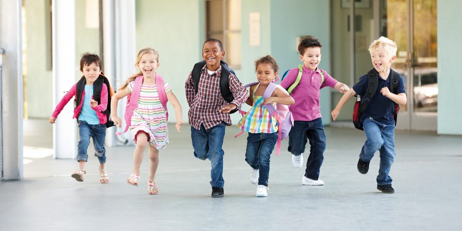 Group Of Elementary Age Schoolchildren Running Outside